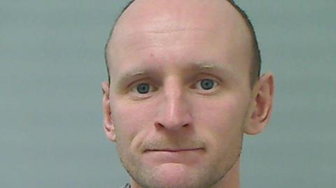 Noel Logan, a man who is balding with dark hair and blue/grey eyes.