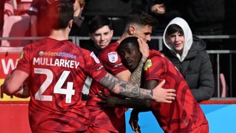 Crawley players celebrate with goalscorer Panutche Camara