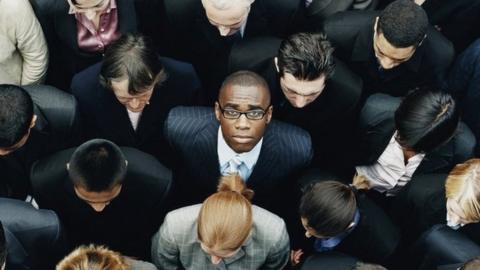 A group of people with a black man in the middle