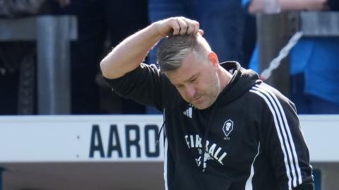 Salford boss Karl Robinson holds his head