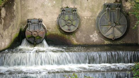 Water discharges from an outlet pipe into the River Mersey next to the United Utilities waste water treatment plant.