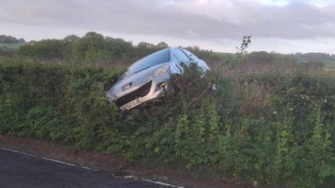 Car overturned in a hedge