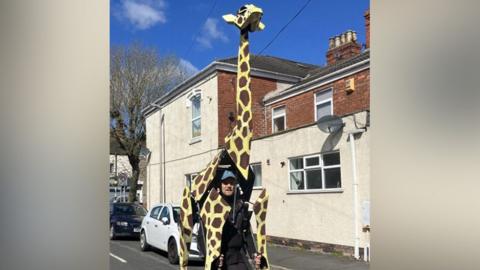 Puppeteer Sebastian Mayer poses inside his giraffe costume