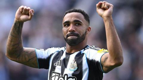 Callum Wilson holds his arms up in the air