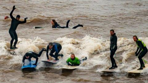 Surfers riding the river Severn bore