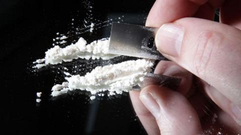 Cocaine being cut into lines with a razor
