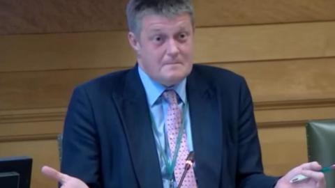 The leader of Wiltshire Council gesticulates with his hands as he makes a passionate address at a council cabinet meeting