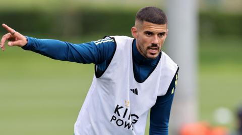 Conor Coady points with his right hand during a Leicester City training session