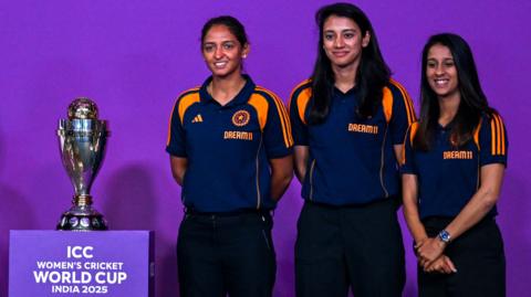 India players Jemimah Rodrigues (R), Smriti Mandhana (C) and Harmanpreet Kaur pose alongside the Women's World Cup trophy