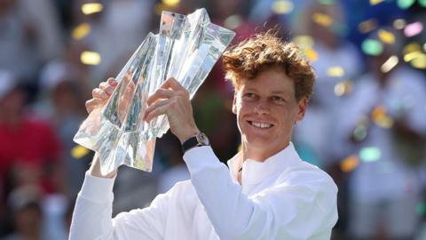 Jannik Sinner holds the trophy in celebration after winning the Indian Wells title