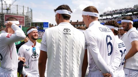 England team before take the field on 'A Day for Thorpey' in memory of England and Surrey cricketer Graham Thorpe on what would have been his 56th birthday on day two of the Fifth Rothesay Men's Test at the Kia Oval, London. They are all wearing cricket whites and have white headbands on.