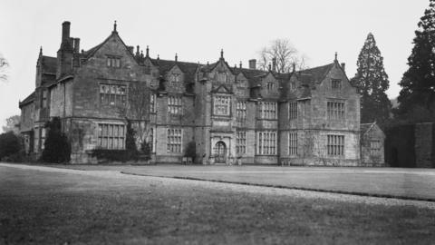 A black and white image of Wakehurst mansion.
