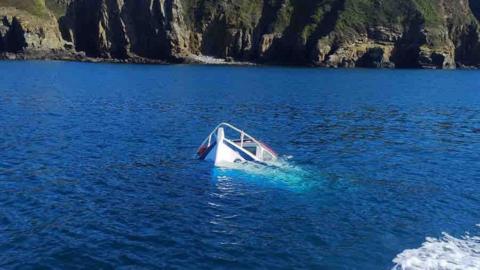 The tip of a sunken boat poking out the ocean off the coast of Sark.