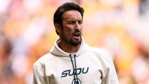 Wolves head coach Cesar Peixoto in cream hooded top shouts instructions to his team during their 3-0 friendly win over Racing Santander