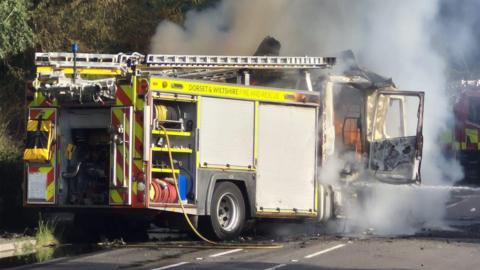 Fire engine caught with its cab on fire on the side of a country road
