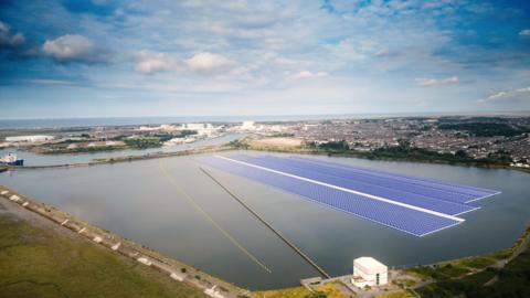 A CGI of how the floating solar farm will look. Three large strips of blue panels are floating across a large section of Cavendish Dock. A town made up of many houses can be seen in the distance. 