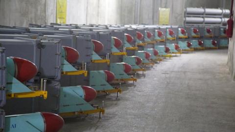 Missiles sit on trailers inside a concrete bunker.