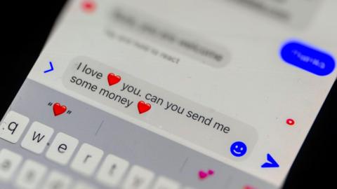 A message on a phone saying "I love (read heart emoji) you. can you send me some money (red heart emoji)