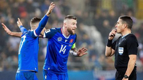 Slovakia players plead with the referee