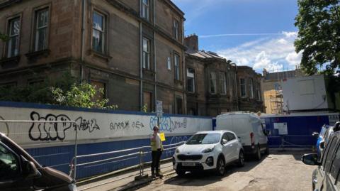 A man on a phone outside the building site