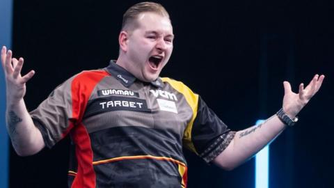 Dimitri van den Bergh celebrates beating Michael van Gerwen