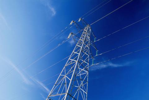 A large electricity pylon with cables against a blue sky