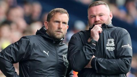 Pete Shuttleworth and Wayne Rooney watch from the sidelines