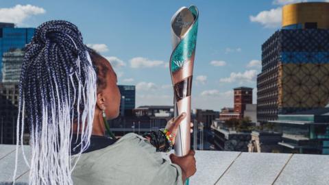 Artist, Laura Nyahuye, holds the Birmingham 2022 Commonwealth Games Queen’s Baton