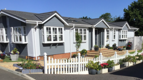A park home with a white picket fence