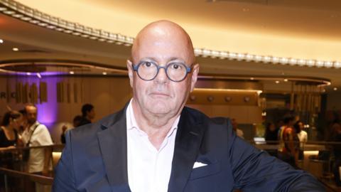 Andre Maeder, Chief Executive of Selfridges, wearing round glasses and a dark suit with no tie