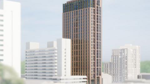 Artist impression of the proposed building. A tall, slim brown building with many glass windows. The top three floors are slightly smaller with green framed windows. Existing buildings round the site are white so the new tower stands out in its surroundings