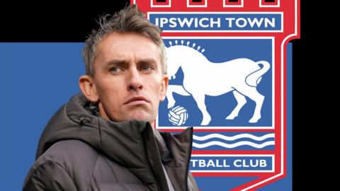 Kieran McKenna in front of a blue and black background and the Ipswich club badge