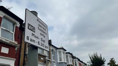 One of the controlled parking zone signs in the borough, with a row of houses in the background