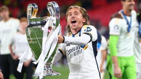 Luka Modric holds up the Champions League trophy