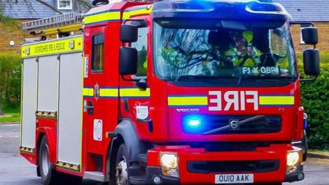 Oxfordshire Fire and Rescue service engine with lights flashing.