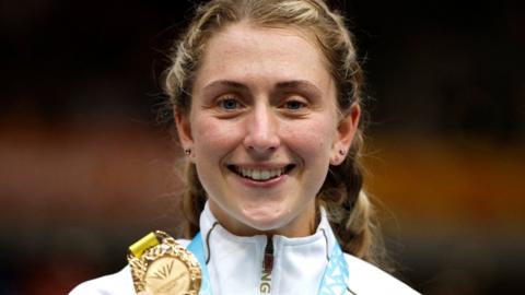 Laura Kenny holds up a medal