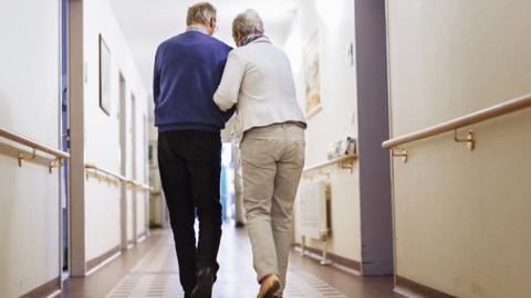 File picture of older people walking down a corridor