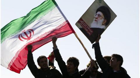 Iranians hold national flag and a picture of Ayatollah Khamenei (file photo)