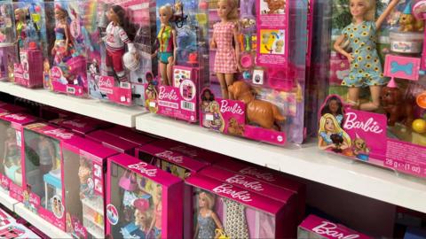 Barbie dolls on a shop shelf.