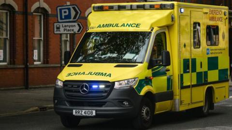 An ambulance driving on Belfast street.