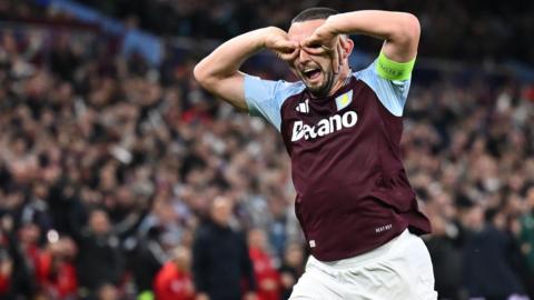 John McGinn runs away, making his hands googles over his eyes, as he celebrates his goal against Bologna. 