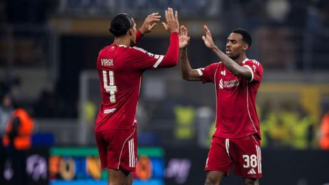 Virgil van Dijk and Ryan Gravenberch high-five each other. 