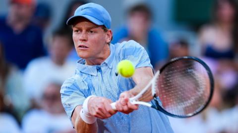 Jannik Sinner hits a backhand