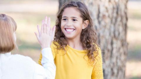 a stock image of two young girls in a high-five