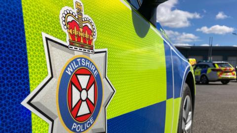 Side of a Wiltshire Police car close-up, showing the logo