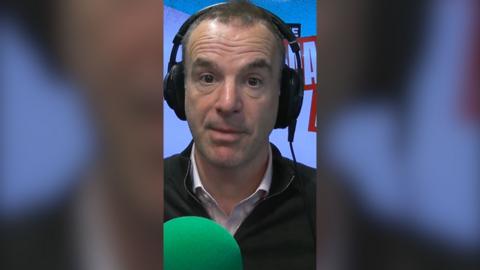 Martin Lewis wears headphones