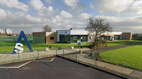 Billingham Skills Academy. It is a brick and glass single-storey building. A tree is growing at the front next to a path.