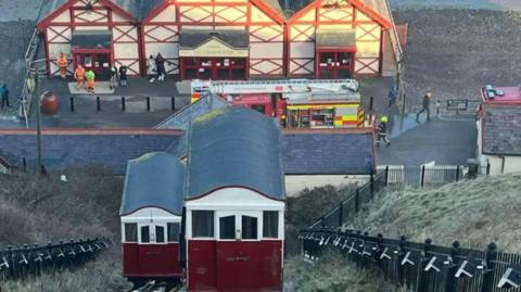 The red tramway with a fire engine and firefighters at the bottom of the hill