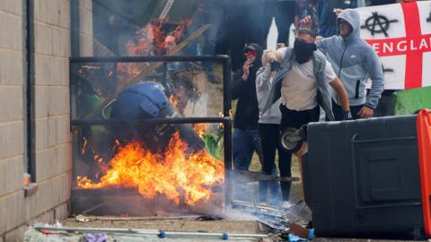 Protestors throwing objects outside a hotel in Rotherham