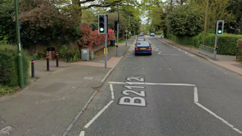 A google maps image of Oathall Road, Haywards Heath. The bollards on the left lead to the pathway into Clair Park.